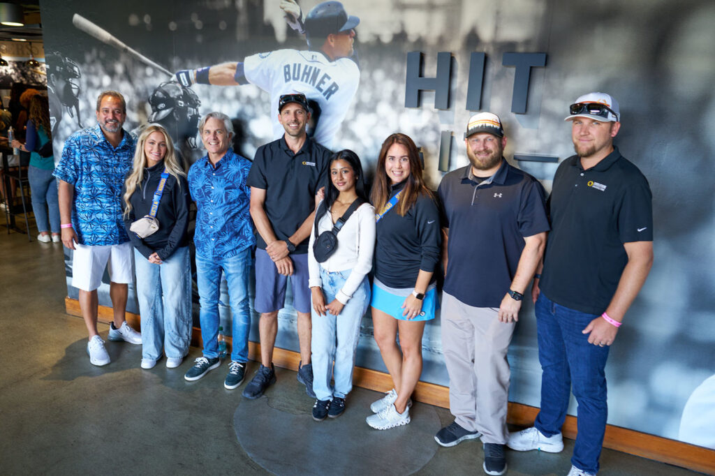 People standing in front of a baseball wall mural