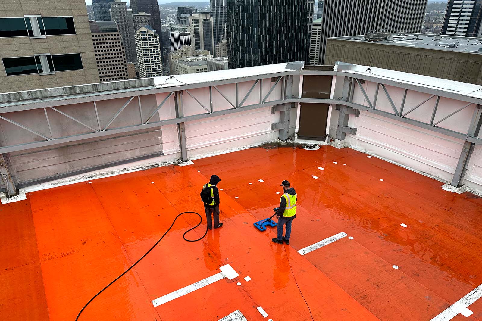 2 workers using electronic leak detection device to solve building leak