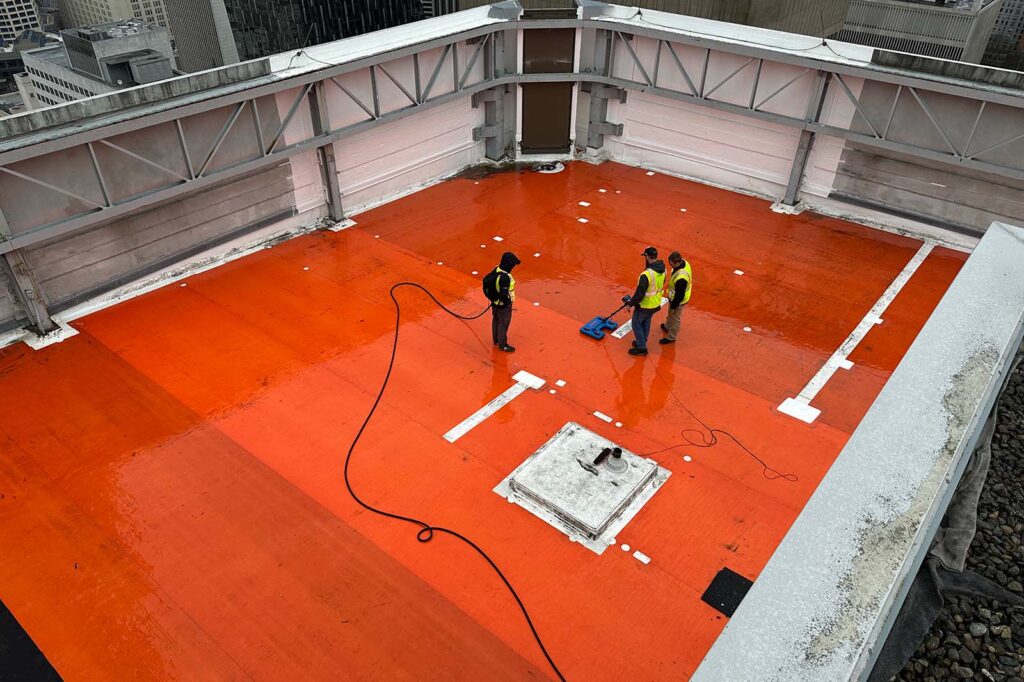3 workers using electronic leak detection device to solve building leak