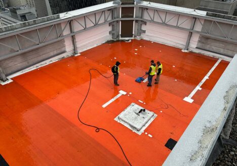 3 workers using electronic leak detection device to solve building leak